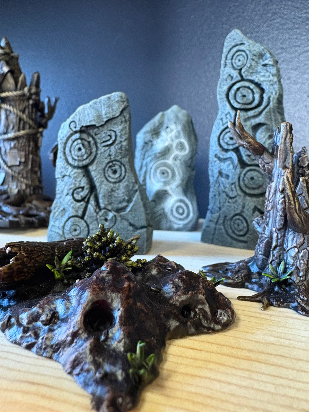 Decorative stone pieces with engraved patterns on a reflective surface.