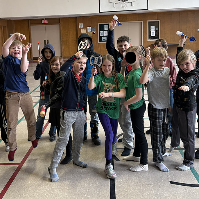 Children in a gym holding plastic throwing axes.